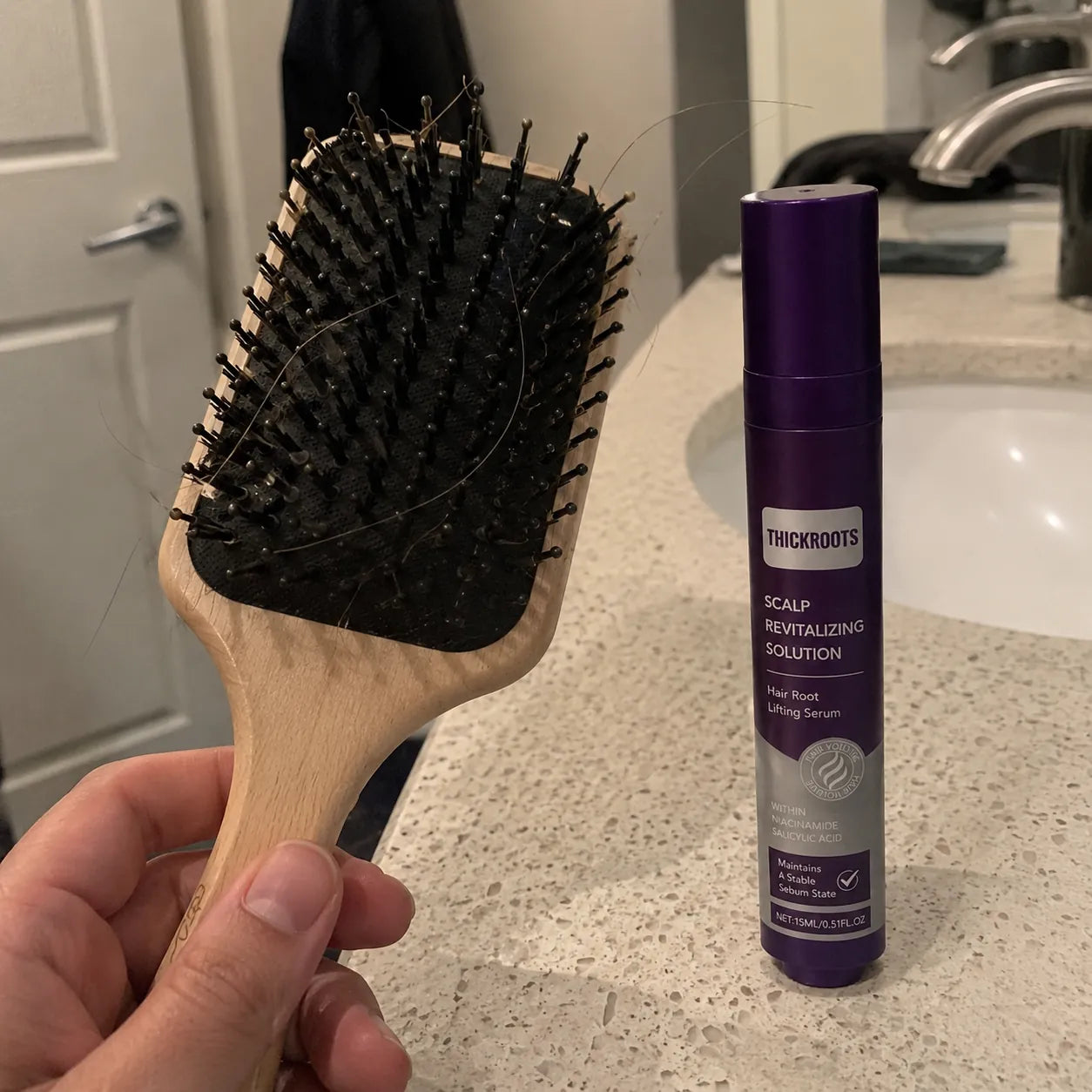Hand applying serum with a brush as part of a routine